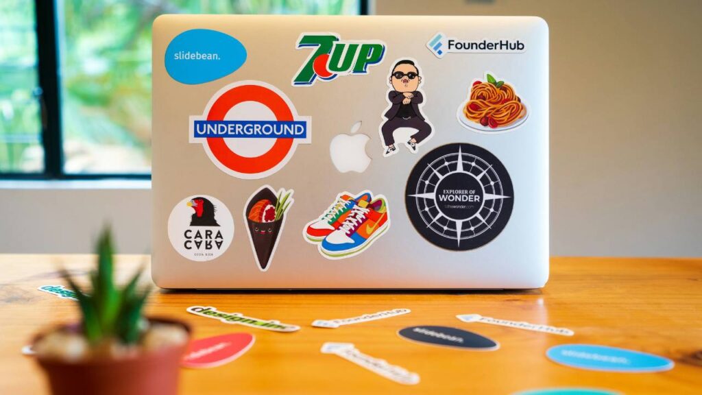 A laptop with colourful brand stickers 
