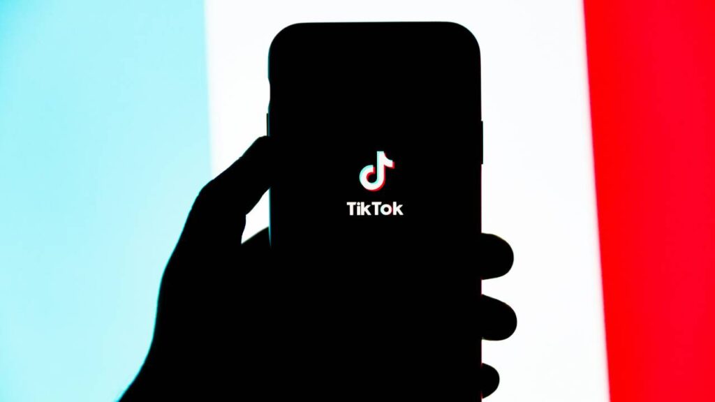 Person holding a smartphone with TikTok app