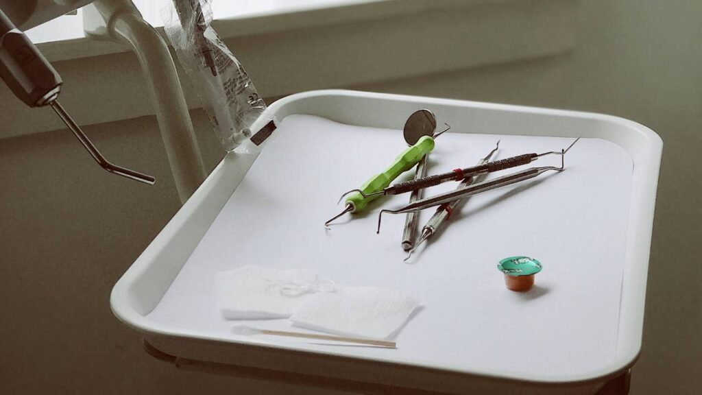 A white tray with various dental tools