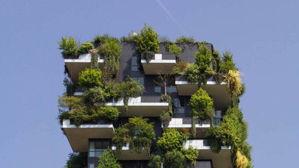 The top part of a building with balconies full of trees 