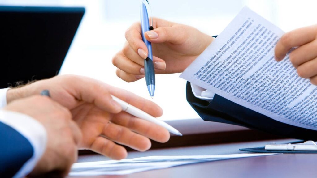 A close-up photo of two businessmen inspecting important documents