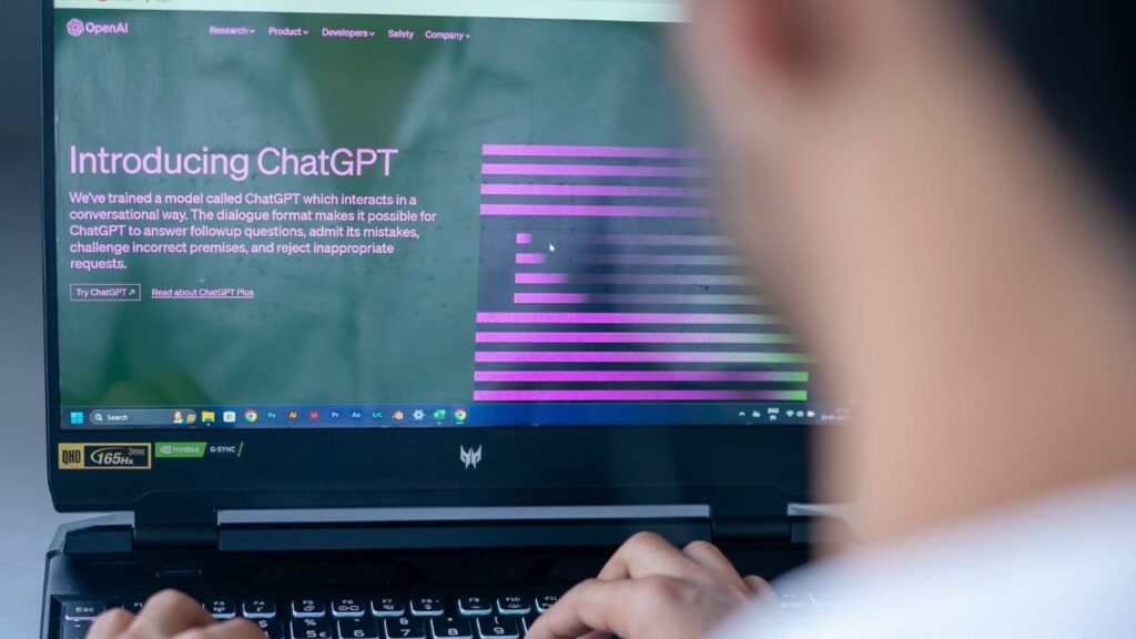 A photo of a man using Open AI's ChatGPT on his laptop